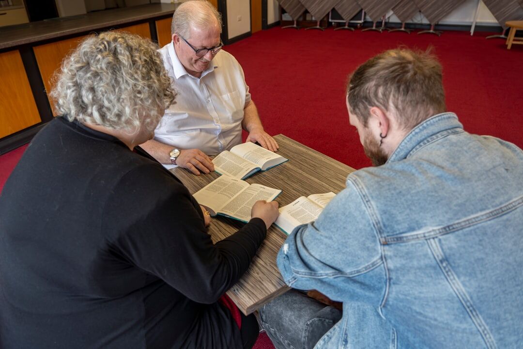 Small team of Argentine editors reviewing manuscripts around a wooden table